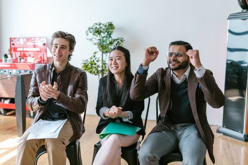 Free A group of diverse entrepreneurs in a workspace celebrating success and motivation. Stock Photo