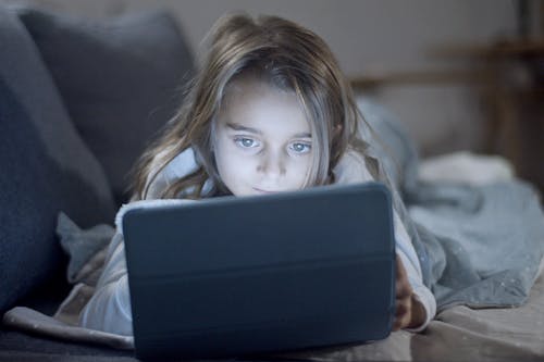 Free Girl in White Long Sleeve Shirt Using a Digital Tablet Stock Photo