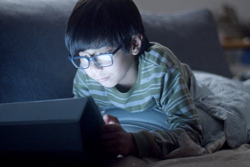 Boy in Green Striped Long Sleeve Shirt Using a Tablet