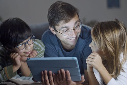 Photo of a Man Looking at His Daughter while Smiling