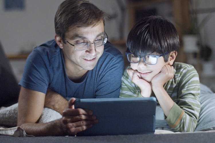 Father And Son Looking At Tablet Screen