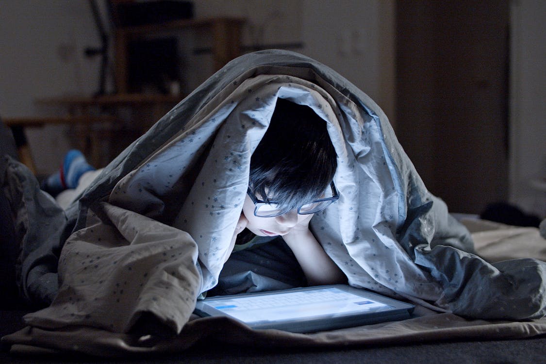 Free A Kid Watching on a Tablet at Bedtime  Stock Photo