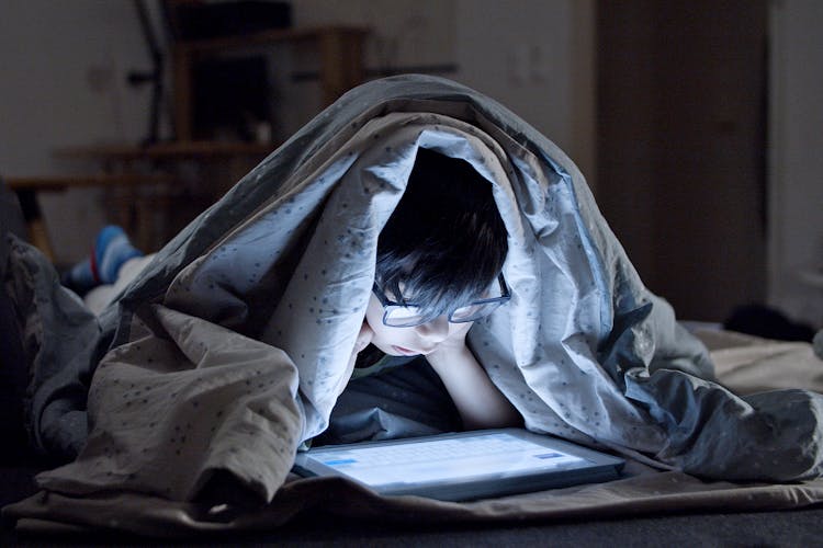 A Kid Watching On A Tablet At Bedtime 