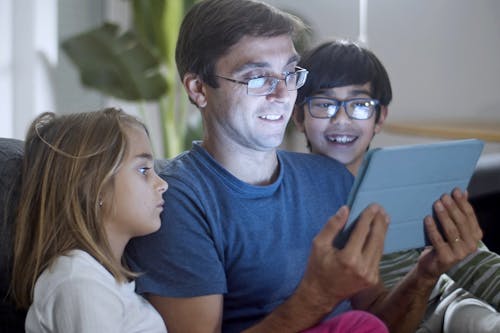 Free Man and Children Watching on a Tablet Stock Photo