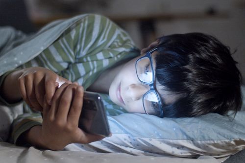 A Boy using Smartphone on the Bed · Free Stock Photo
