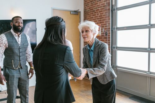 Free Three entrepreneurs meeting and shaking hands in a modern office setting. Stock Photo