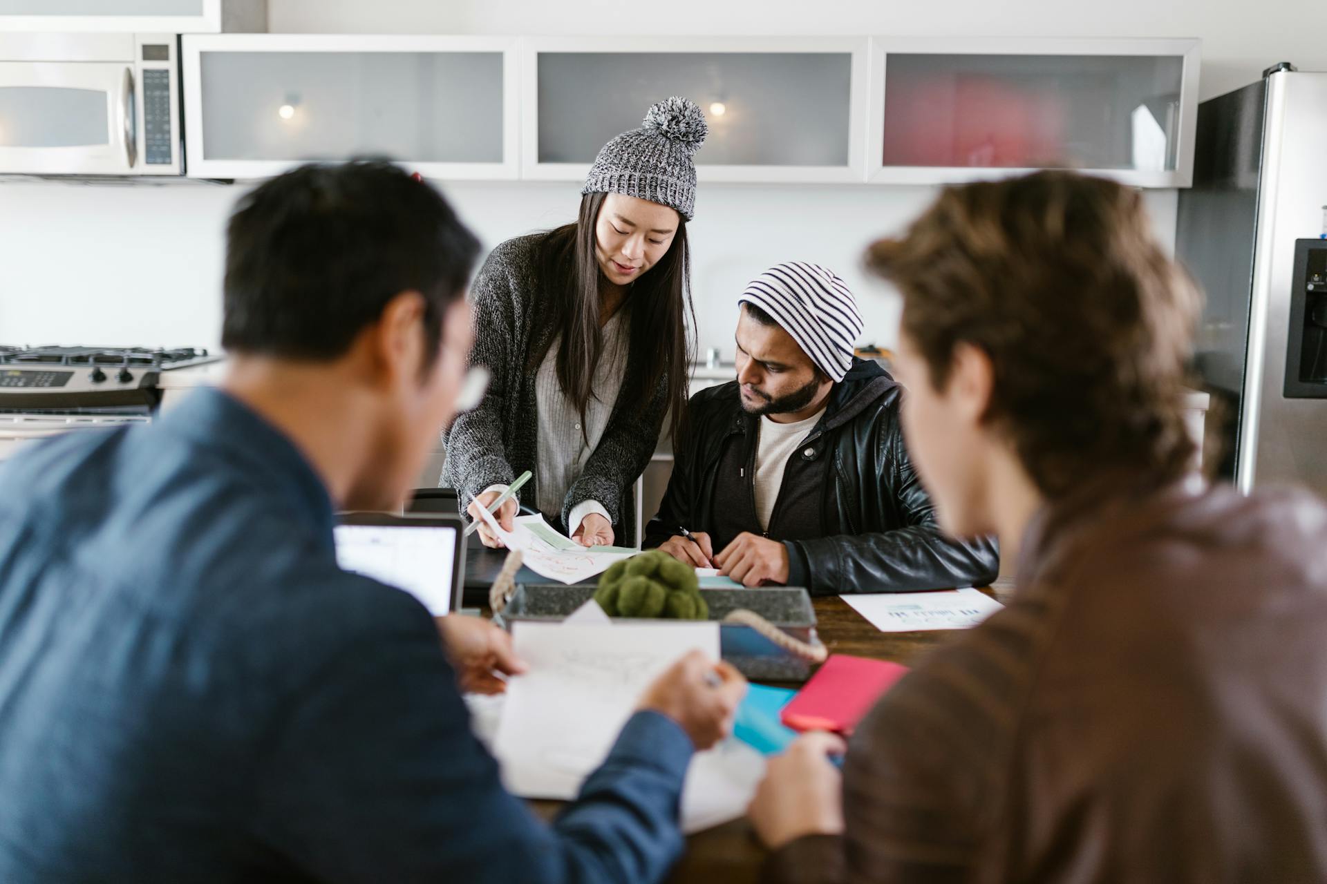 A dynamic group of young entrepreneurs brainstorming in a well-lit office space.