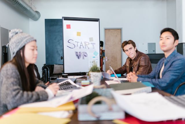 A group of young professionals brainstorming ideas in a startup office setting. Related image for Hospitality Startups: Key Lessons for Owners and Operators.
