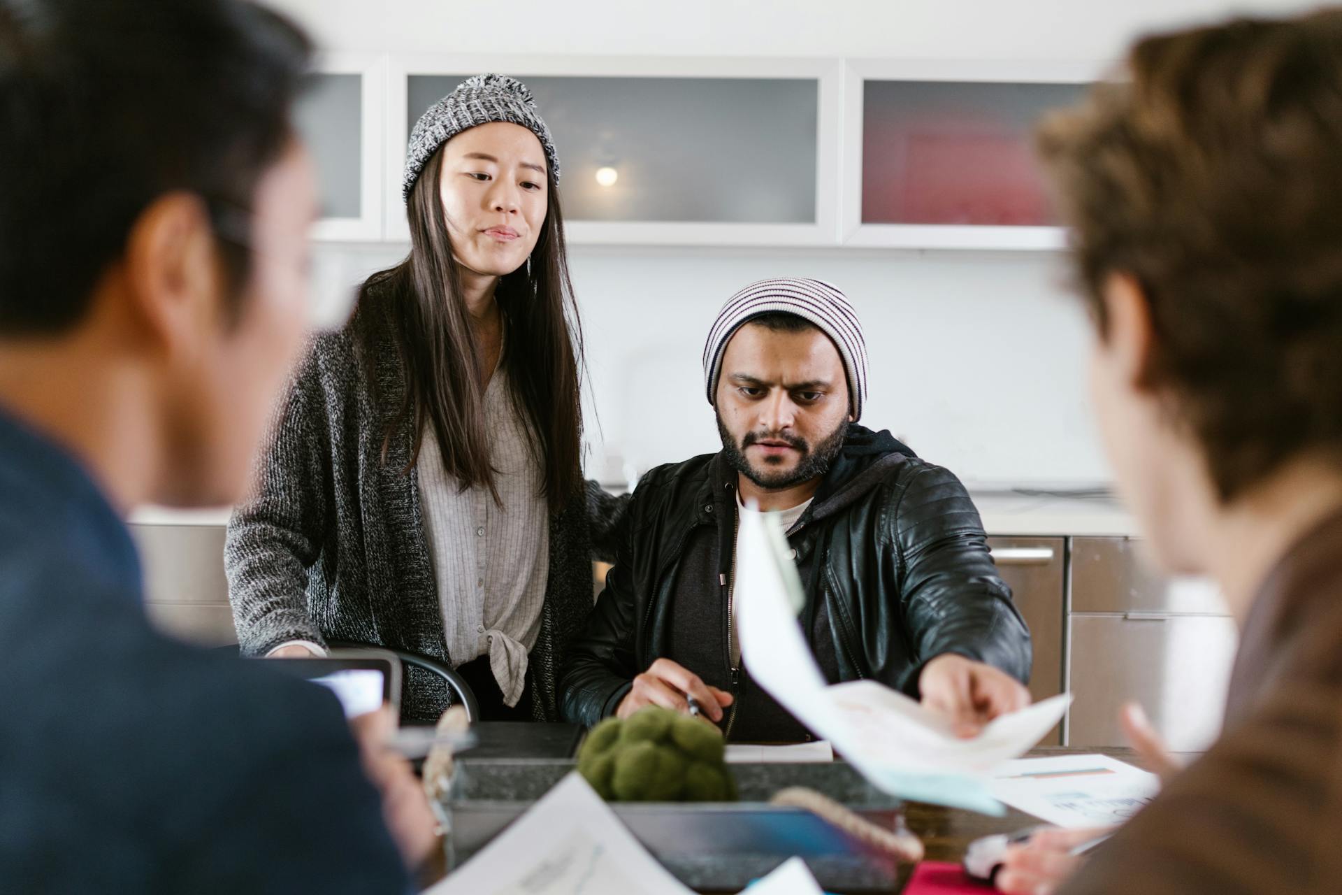 Group of young entrepreneurs brainstorming and collaborating in a modern office setting.