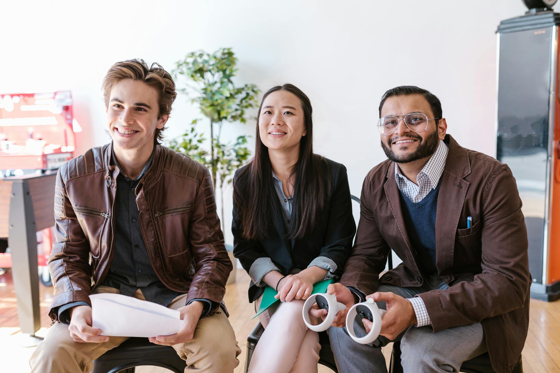 Young entrepreneurs seated together, engaged in a business discussion with positive expressions.