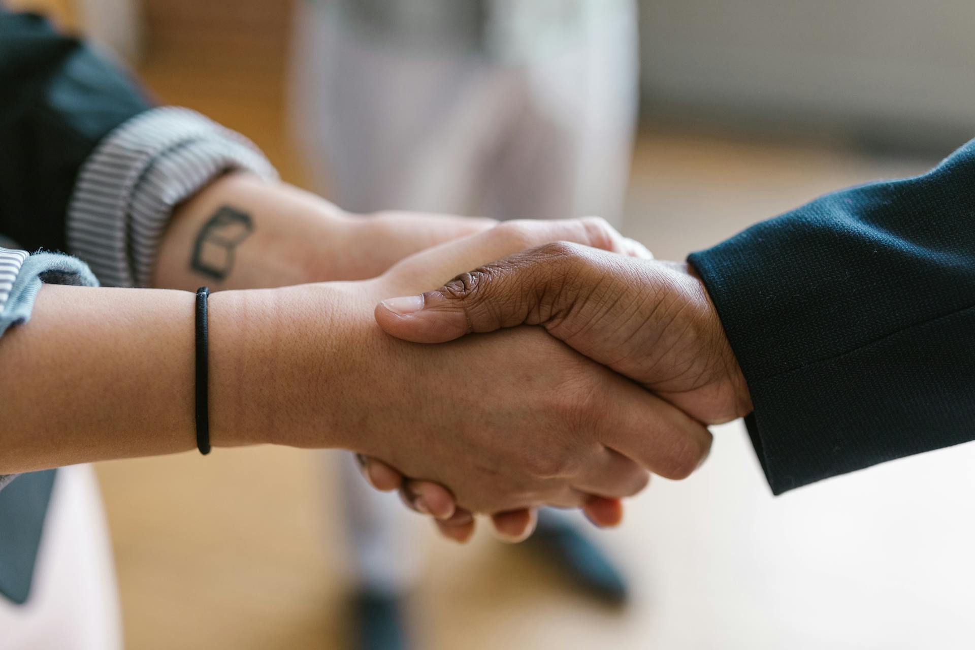 A close-up of two people shaking hands, symbolizing agreement and collaboration.