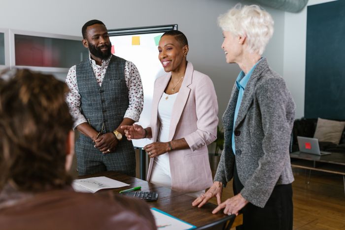 Three colleagues standing together outside, photo by RDNE Stock project on Pexels