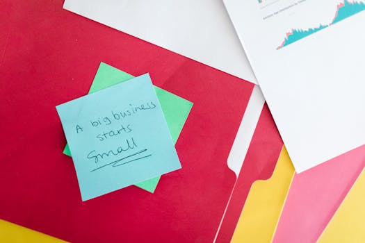 Colorful folders and a motivational business quote on a note for inspiration and success.