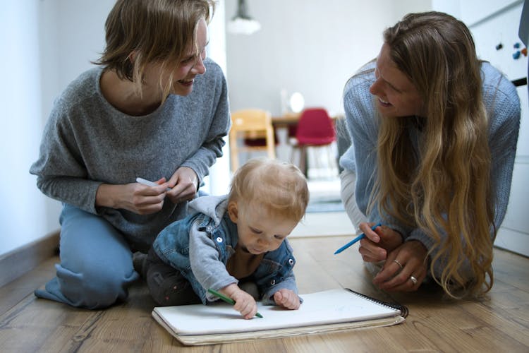 Women With Baby Writing On Notebook