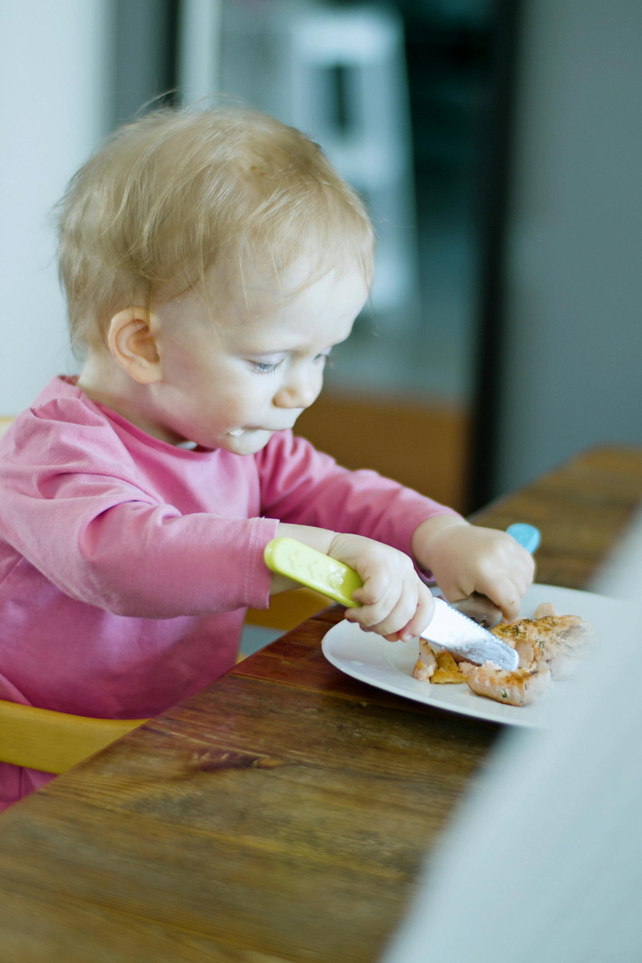 little girl in pink long sleeve shirt eating