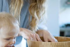 Mother and toddler cooking together, toddler holding a red bell pepper.