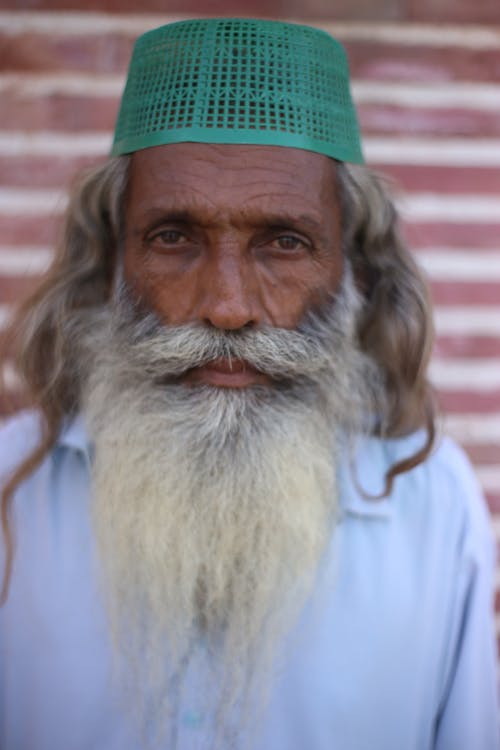 A Man in Green Cap and White Shirt