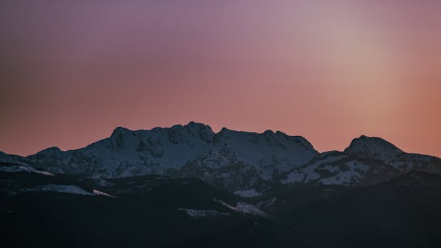 Captivating view of snow-capped mountains at twilight with a pink sky in British Columbia, Canada.