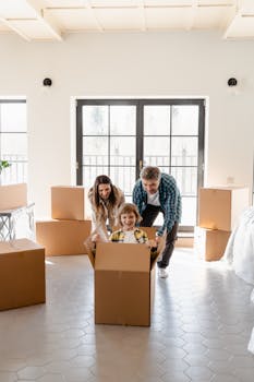 Family playing with moving boxes at home, creating happy moments indoors.