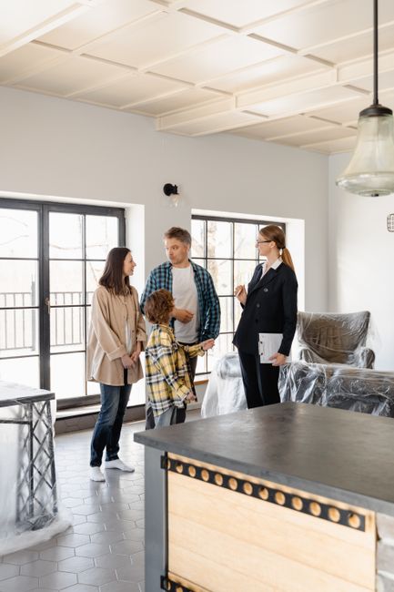 Family explores a new home with a realtor, discussing the property details.