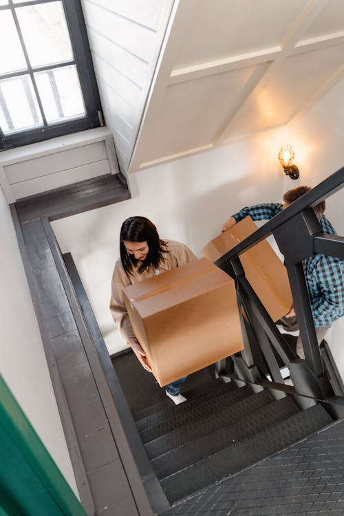 Free A Couple Carrying Boxes while Going Up the Stairs Stock Photo