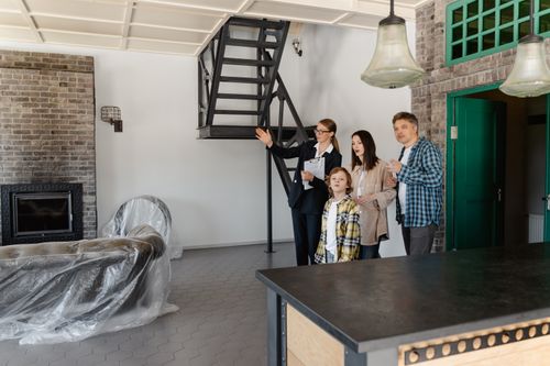 Free Family and agent exploring a stylish new home interior together. Stock Photo