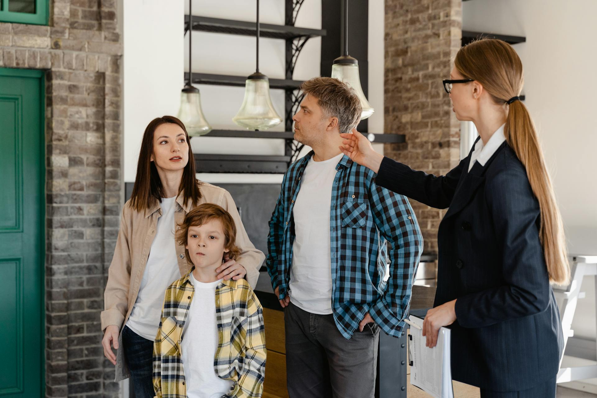 A family visits a modern home guided by a real estate agent during an open house tour.