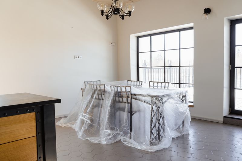 Mover carefully wrapping a dining table in a protective blanket