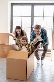 Happy family playing with boxes while moving into a new home, full of joy and excitement.