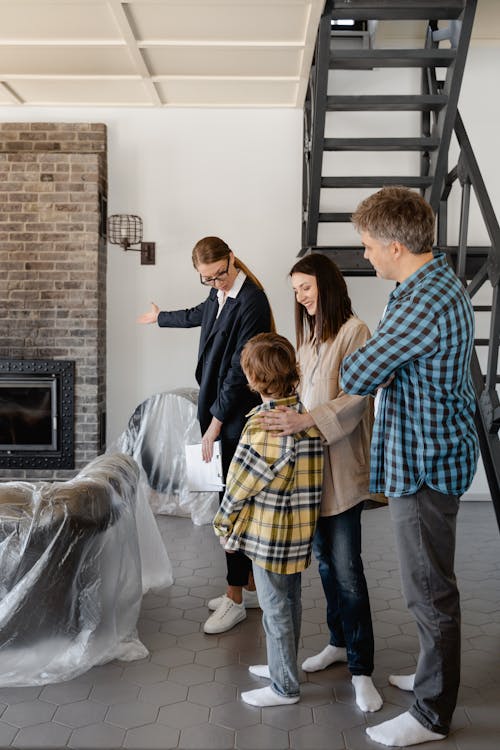 A Real Estate Agent Showing the Living Room to Her Clients