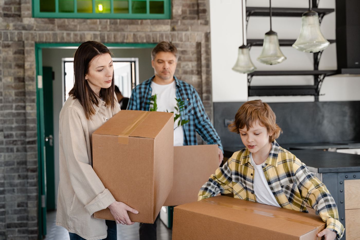 Family carrying boxes while moving to a new home