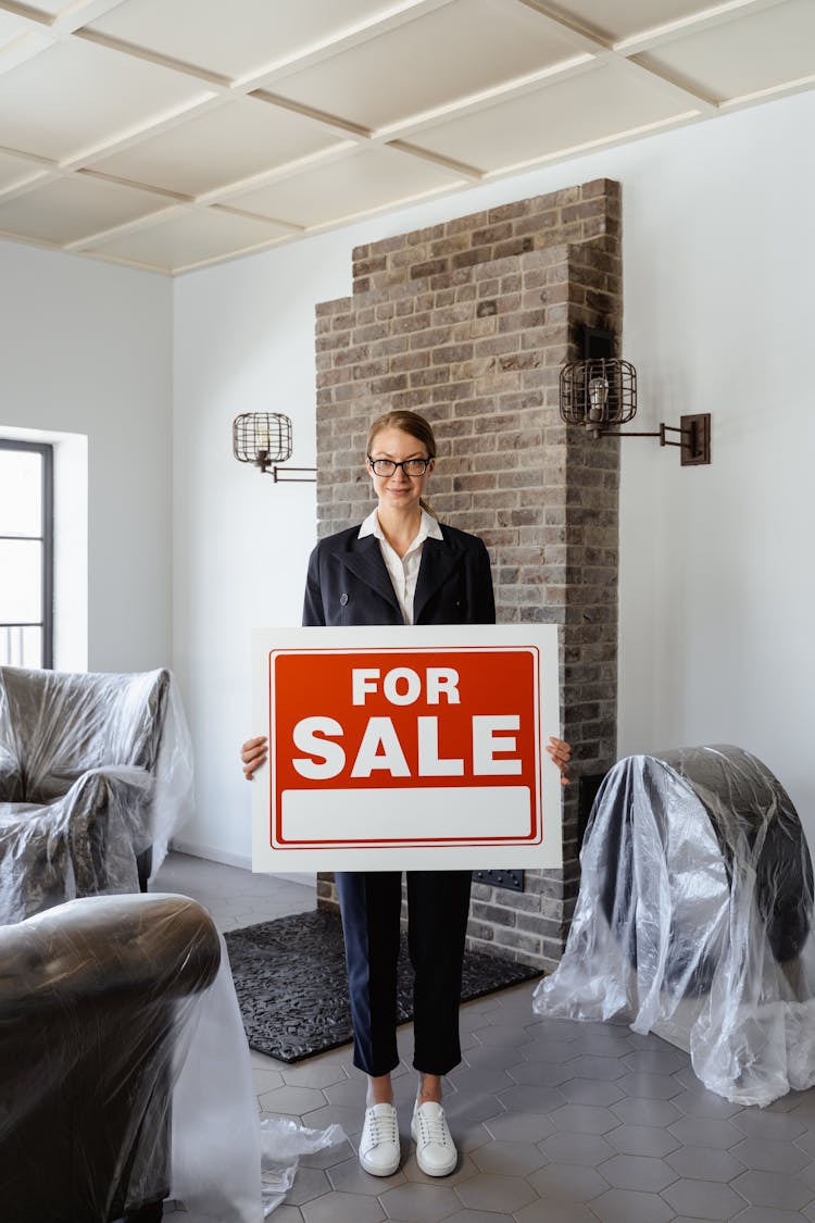 A Woman Standing While Holding A Placard