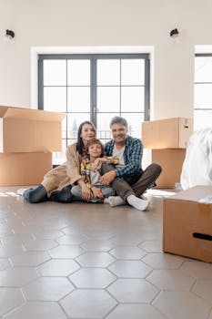 A family of three happily unpacks boxes in their bright new home.