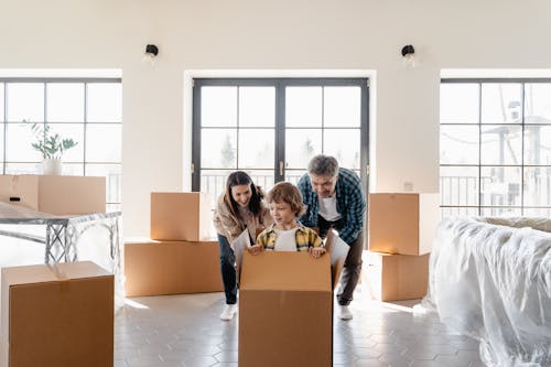 Free A Couple Looking at their Son Inside the Box Stock Photo