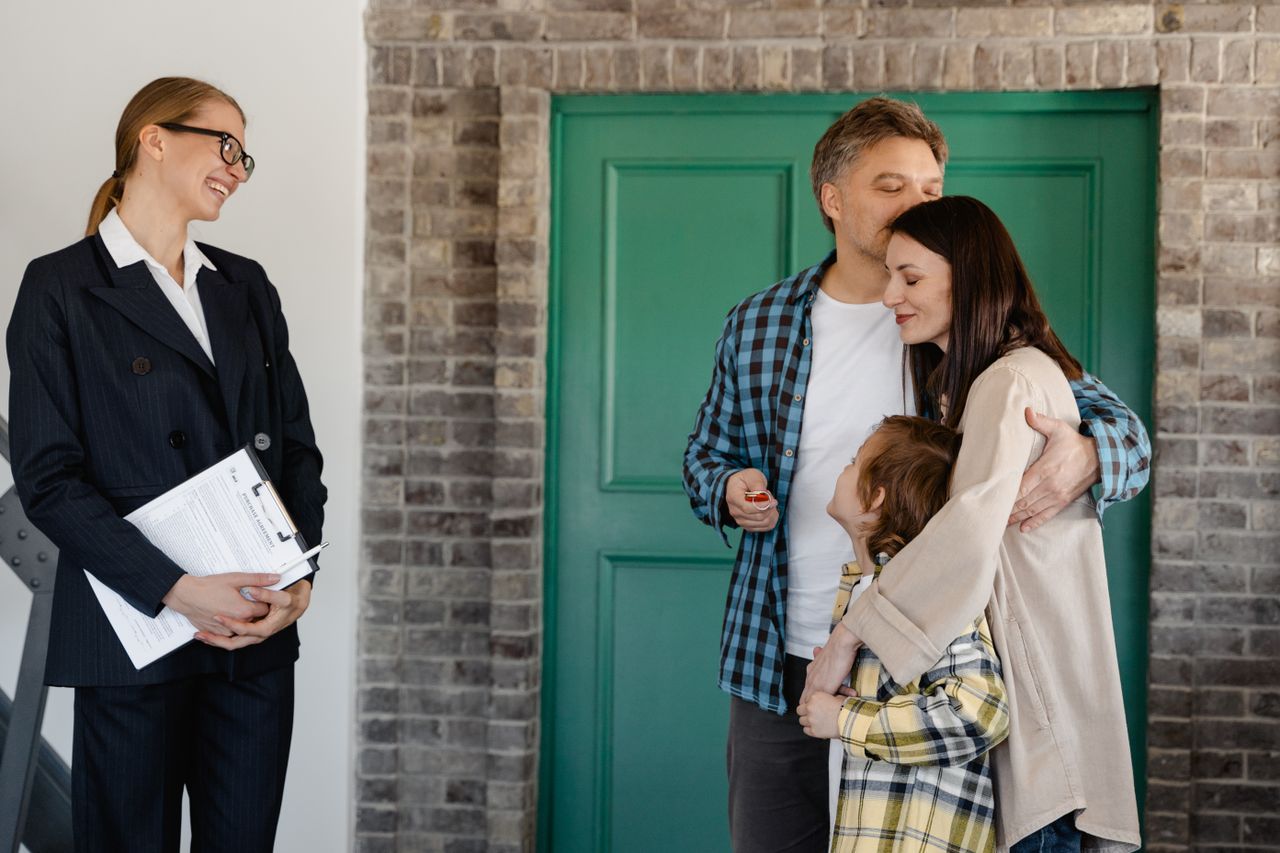 Happy family embracing at the front door of their home