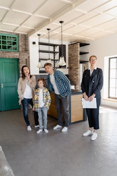 A family explores a modern kitchen with a real estate agent present, evaluating their new home.