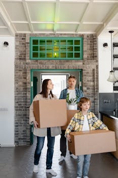 A family carrying boxes as they move into their new home, symbolizing new beginnings.