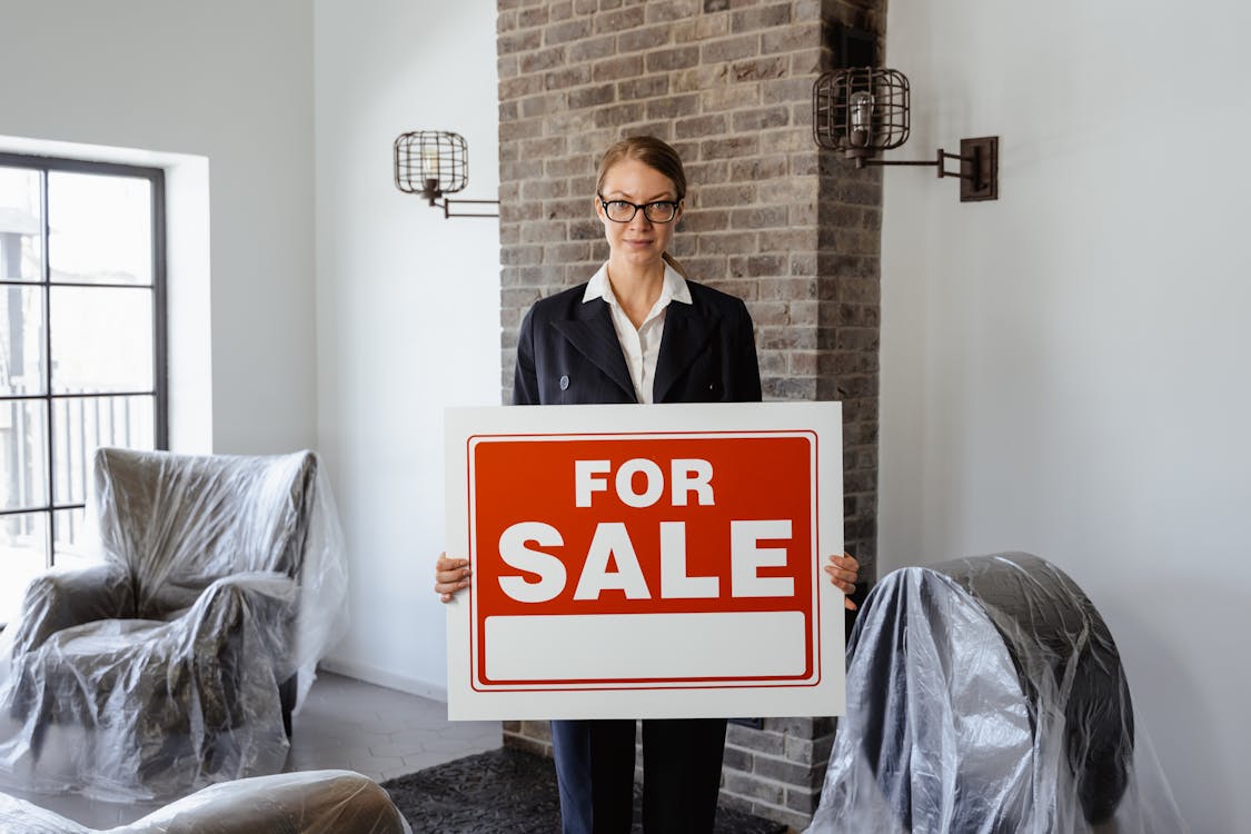 Free A Real Estate Agent Holding a Sign Stock Photo