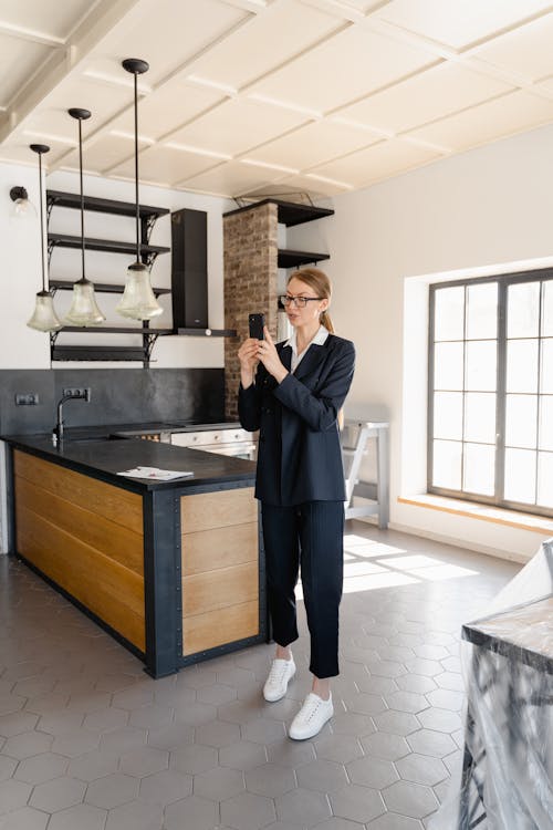 A Woman in Black Suit Standing Near the Kitchen Counter