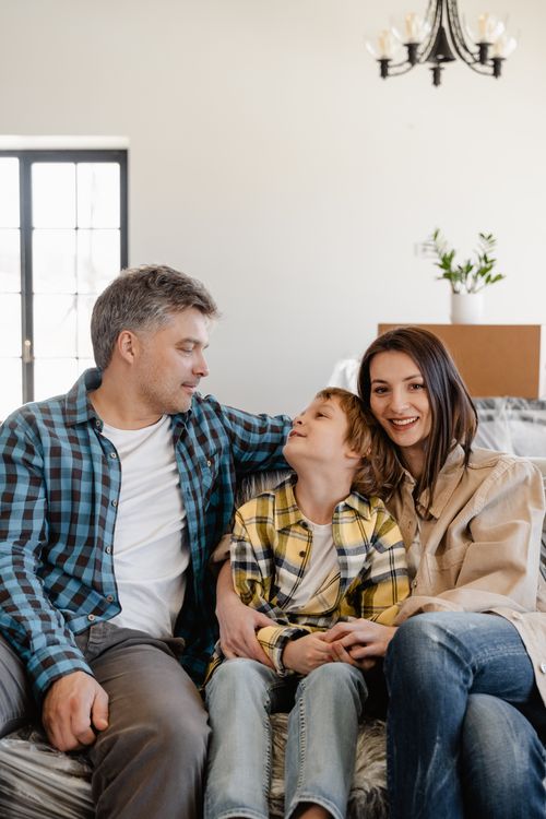 Free A joyful family sitting together while unpacking in their new home living room. Stock Photo