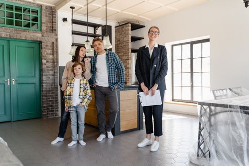 Free A family tours a modern home with a real estate agent, showcasing interior design. Stock Photo