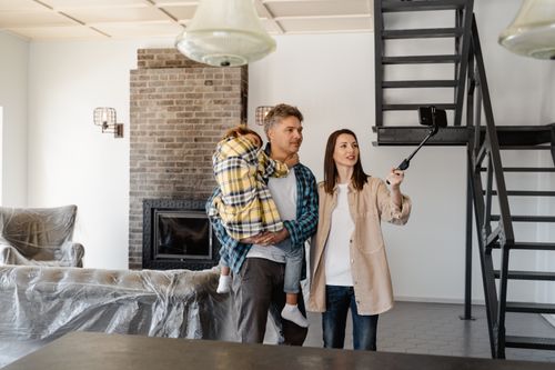 Free Family capturing memories with a selfie while moving into their new home. Stock Photo