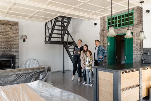 A family exploring a modern home with a real estate agent, featuring industrial interior design.