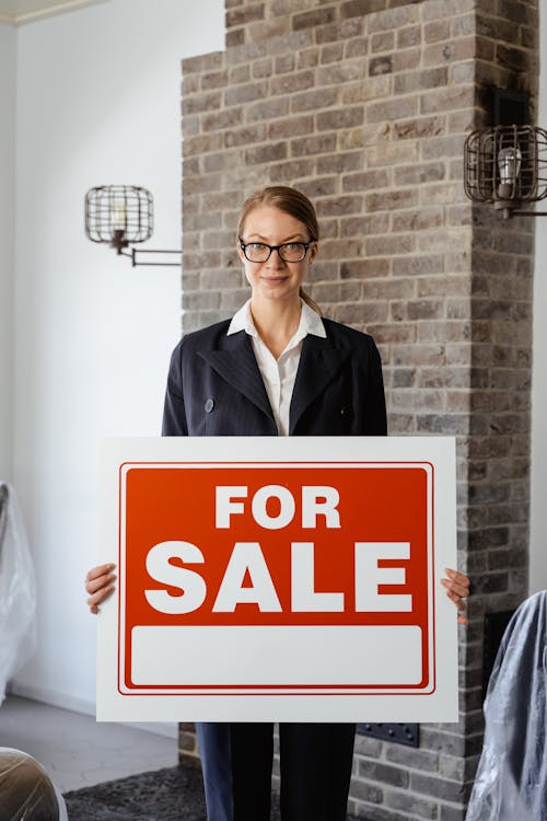 Free 
A Real Estate Agent Holding a Sign Stock Photo