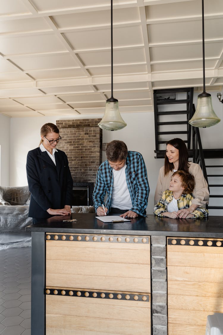 A Man Signing A Purchase Agreement For The Newly Bought House