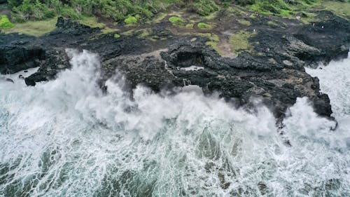
An Aerial Shot of Waves Crashing on a Rocky Shore