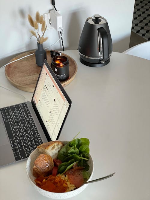 Free Laptop on charge placed with bowl of tasty food Stock Photo