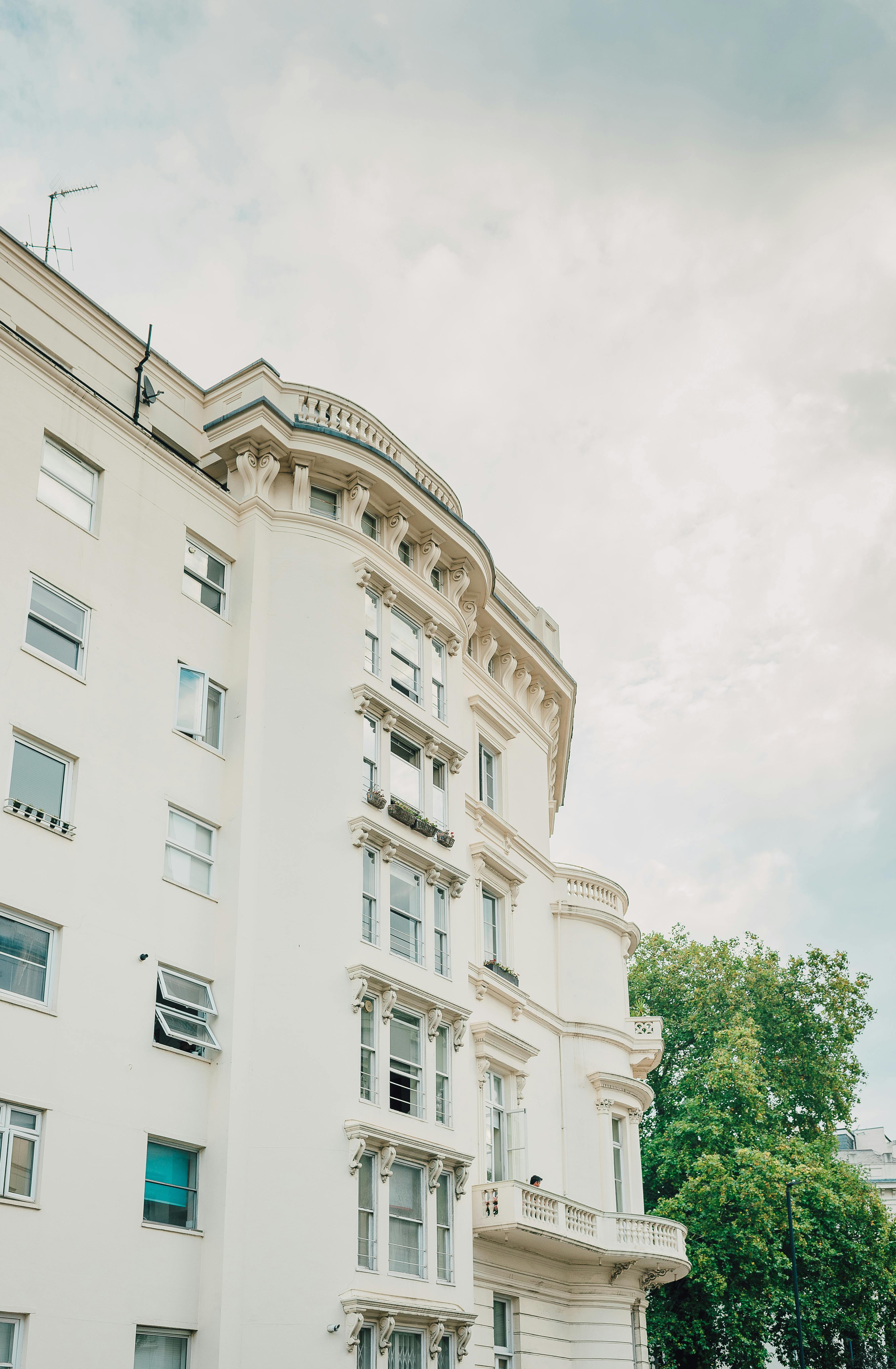 Low angle view of a classic London apartment building with ornate architecture under a cloudy sky.