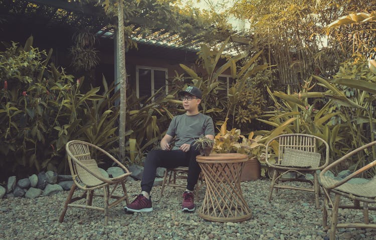 Man Sitting On The Chair In A Garden