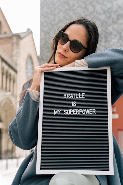 Woman Wearing Black Sunglasses Holding Letter Board